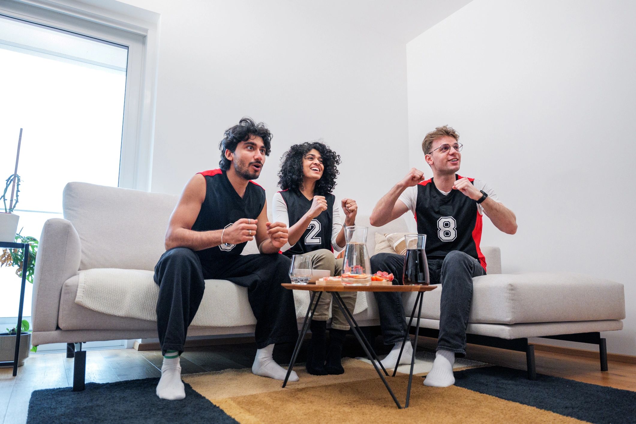 Friends cheering while watching a game together