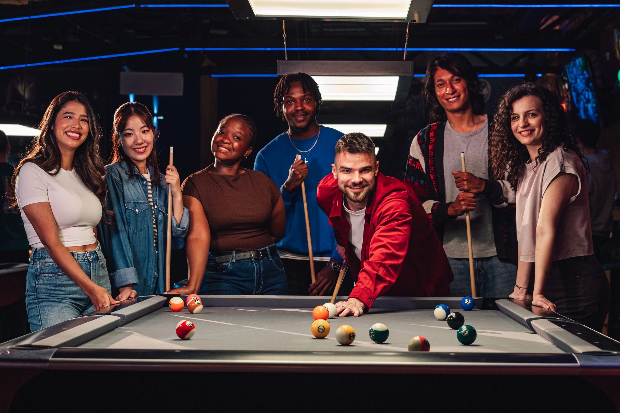 Friends playing pool in a lively bar